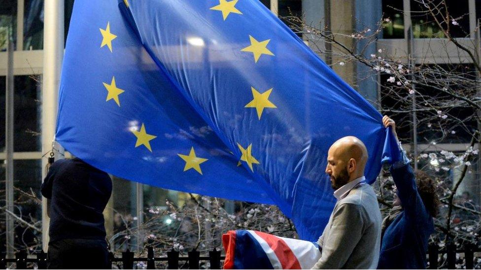 Workers replace the union flag outside the European Parliament building with the European Union flag, as Britain leaves the European Union