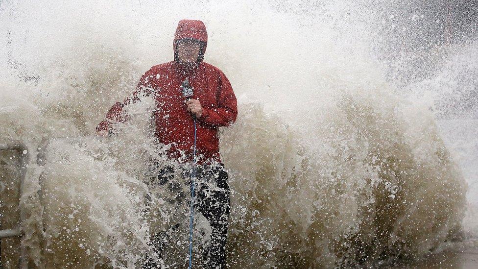 A news reporter doing a stand up near a sea wall in Cedar Key, Florida is covered by an unexpected wave as Hurricane Hermine nears the Florida coast, Thursday, 1 September 2016.