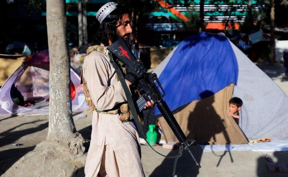 Taliban soldier at displaced family camp