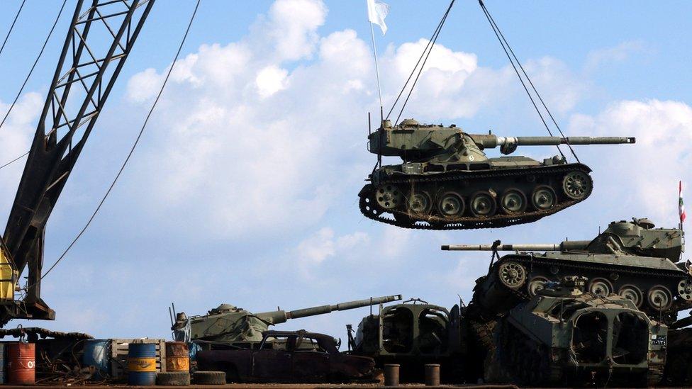 Workers unload old army tanks into the Mediterranean sea off the coast of Sidon, Lebanon, 28 July 2018.