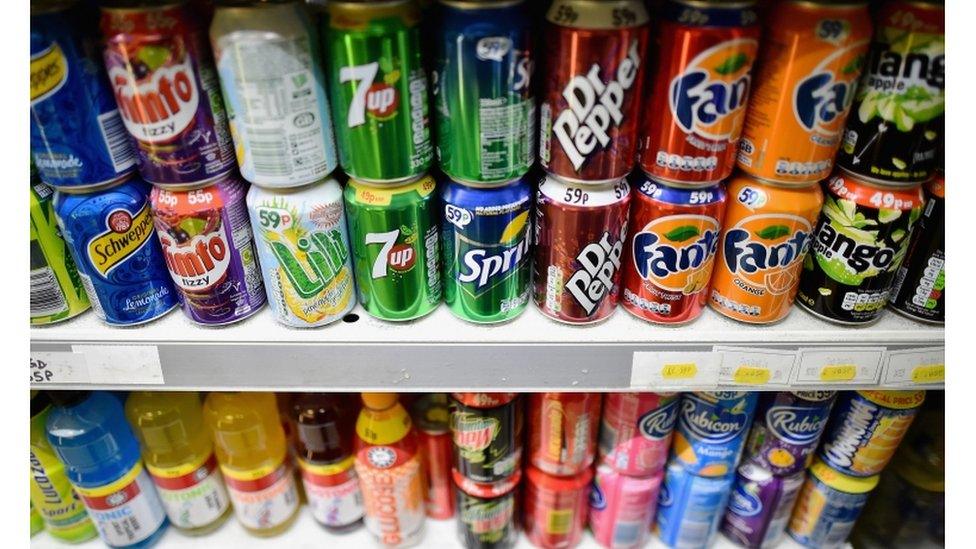 Fizzy drinks cans on a shelf