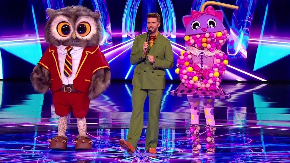 Owl and bubble tea standing with host joel dommett.