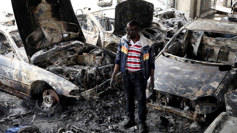 Man inspecting fire damaged car lot