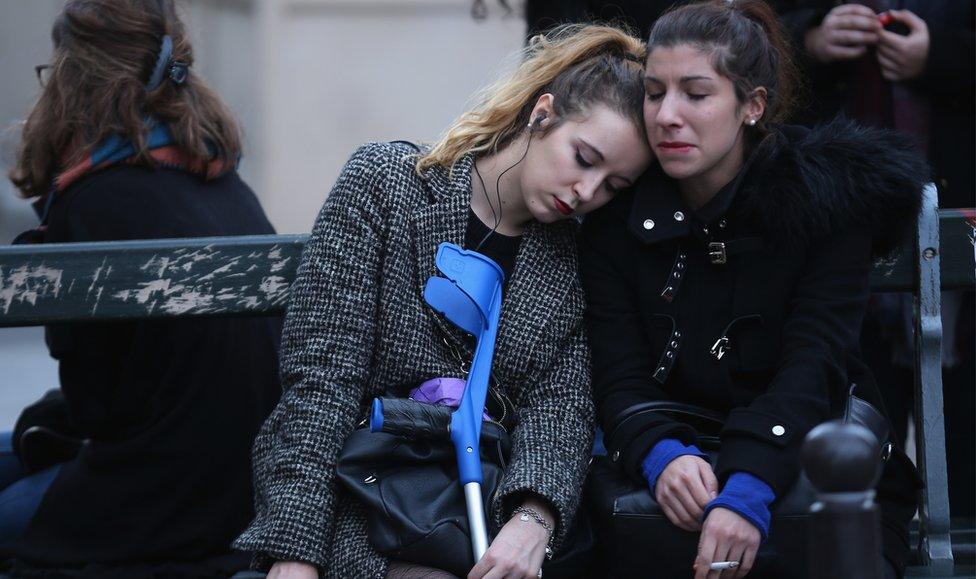 Two women pause for thought outside Le Carillon restaurant in Paris (16 Nov)