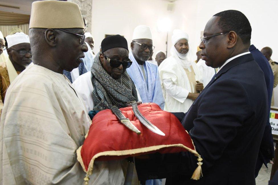 Senegal President Macky Sall (R) receives the sword El Hadj Omar Tall during a ceremony with French Prime Minister Edouard Philippe at the Palace of the Republic in Dakar, Senegal, on November 17, 2019.