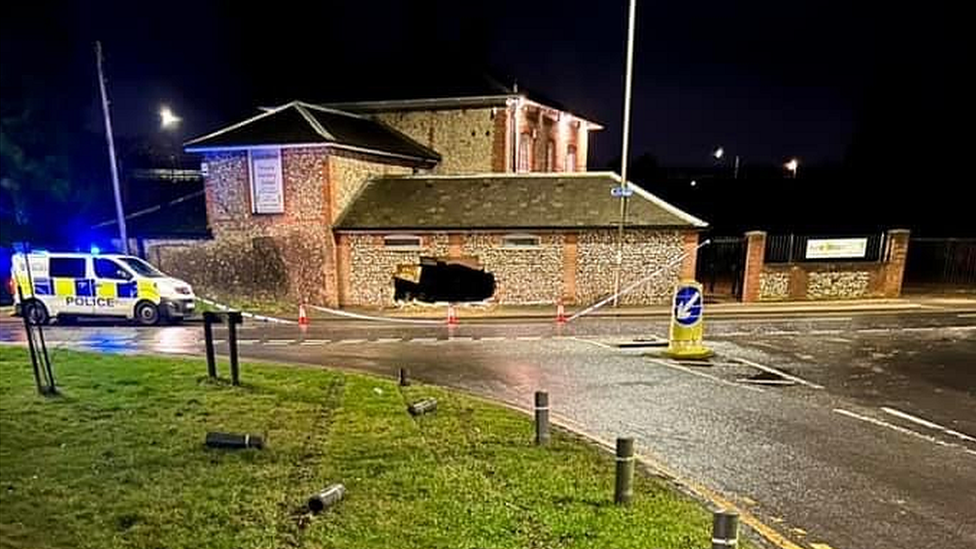 Crash scene - building with hole where car has smashed into it