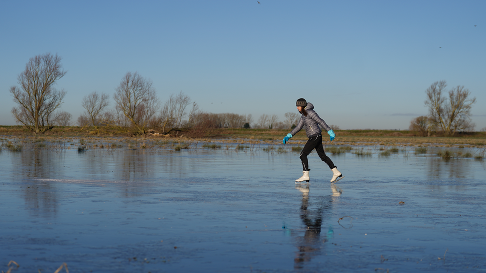 Fen skaters on a frozen lake in Upware, Cambridgeshire