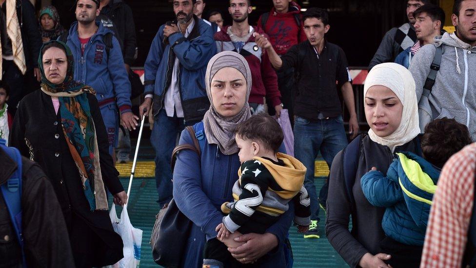 Syrian refugees exit a ferry near Athens, Greece.