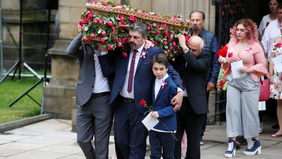 Andrew Roussos puts a hand around his son Xander as he carries his daughter Saffie Rose Roussos" coffin