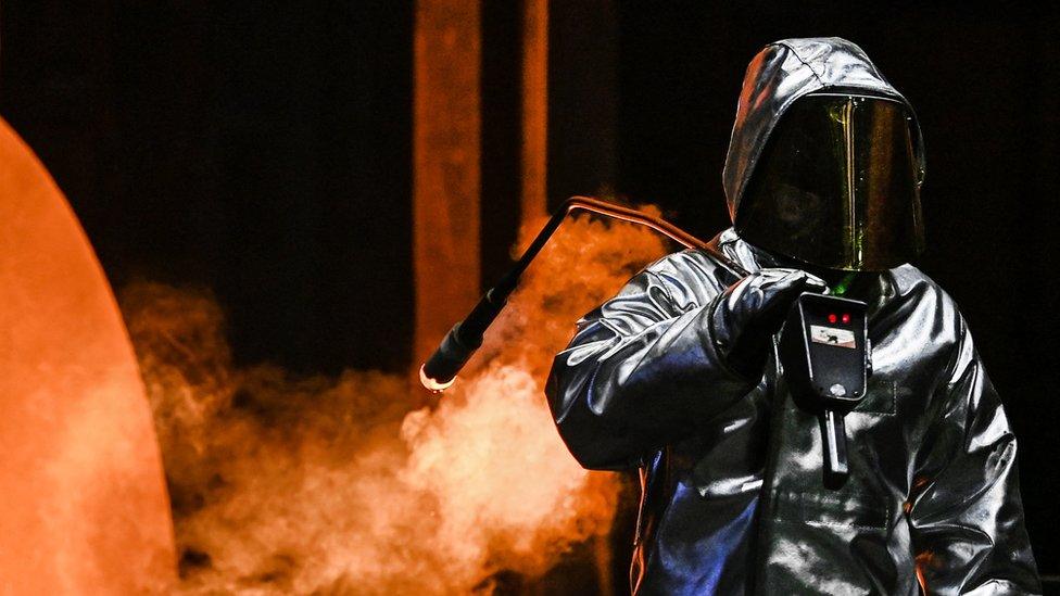 An employee takes a sample at the blast furnace at the ThyssenKrupp plant in Duisburg, western Germany