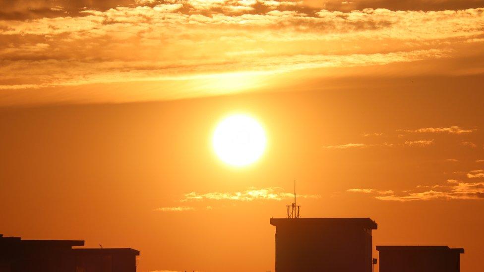 Sun above buildings