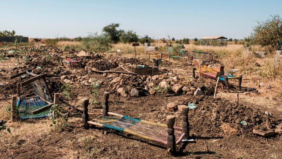 This photograph taken on November 21, 2020 shows abandoned beds used as stretchers to carry bodies, laying next to collective graves at a cemetery, of victims that were allegedly killed in the November 9, 2020 massacre, in Mai Kadra, Ethiopia