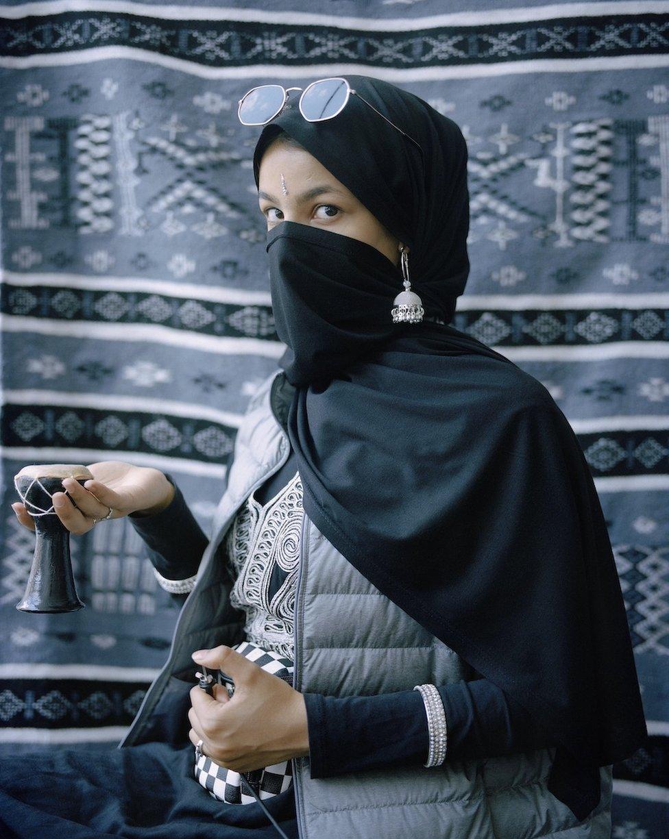 Portrait of woman wearing various cultural clothes, looking to the camera