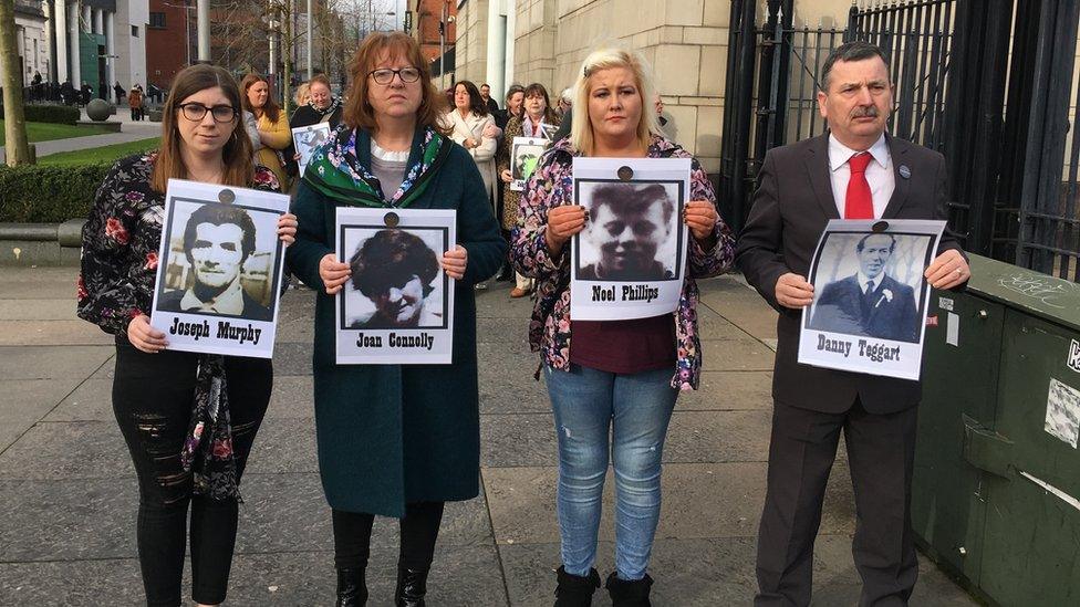 Relatives of Joseph Murphy, Joan Connolly, Noel Phillips and Daniel Teggart hold images of their loves ones outside the court in Belfast where the inquest is taking place