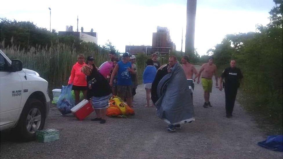 Police in Sarnia, Ontario tweet a photo of US boaters after they had been rescued from the St. Clair River.