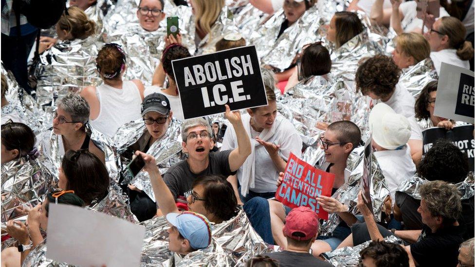 Protester holding sign saying Abolish Ice