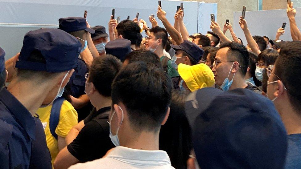 People gather to demand repayment of loans and financial products at the Evergrande's headquarters, in Shenzhen, Guangdong province, China.