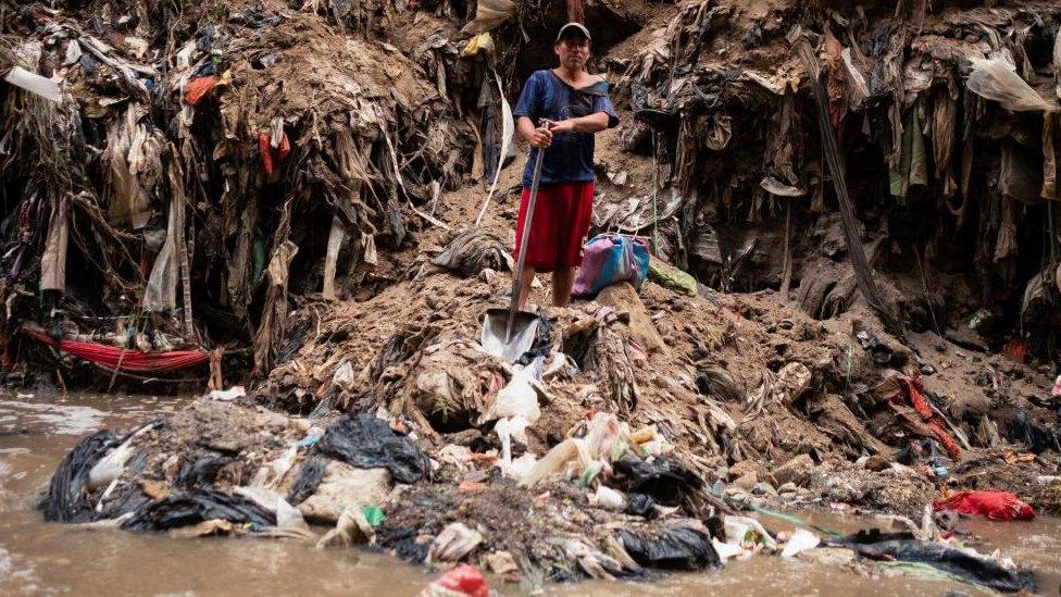 A man poses for a portrait after working in the polluted waters of the Las Vacas river