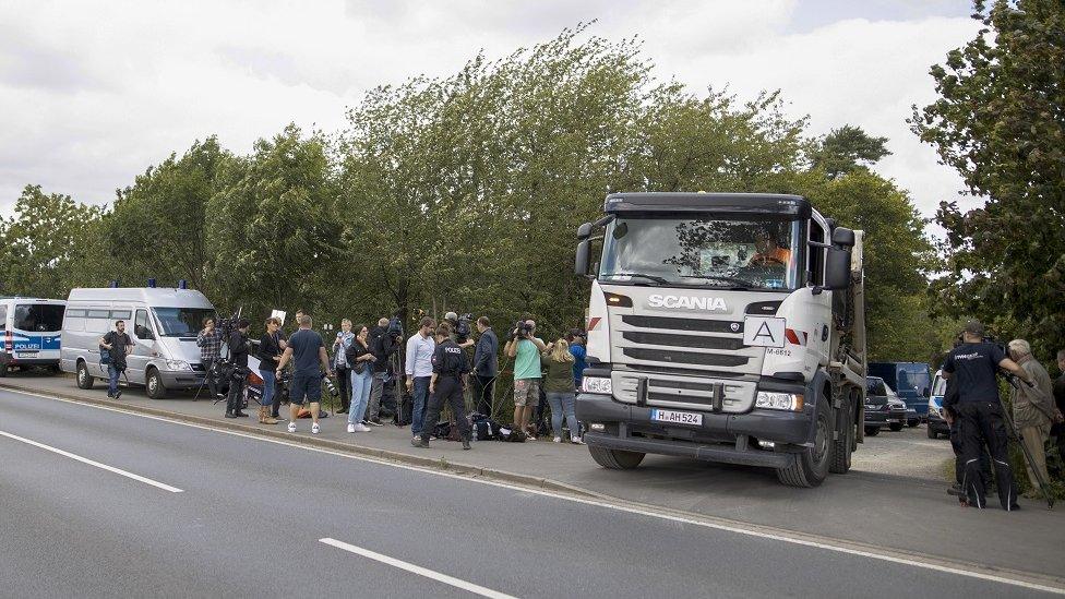 A truck transports a container with excavated earth as officers search a garden plot in Hannover, northern Germany, 29 July 2020.