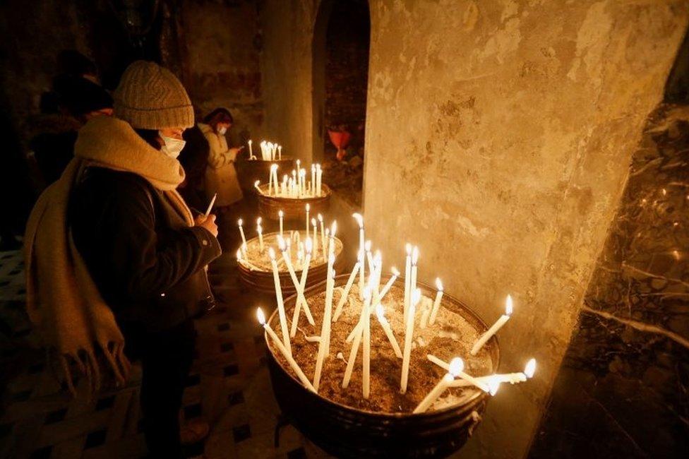 People light candles before a Christmas Eve service at St Mary Draperis Roman Catholic Church in Istanbul, Turkey. Photo: 24 December 2021