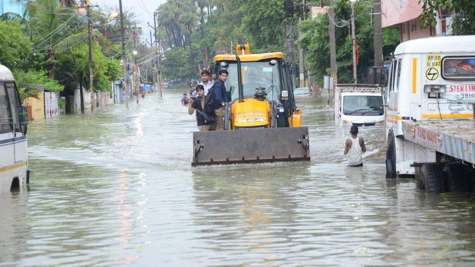 A digger on a flooded road