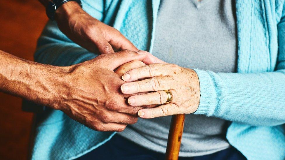 Close up of male holding hands of senior woman, - stock photo