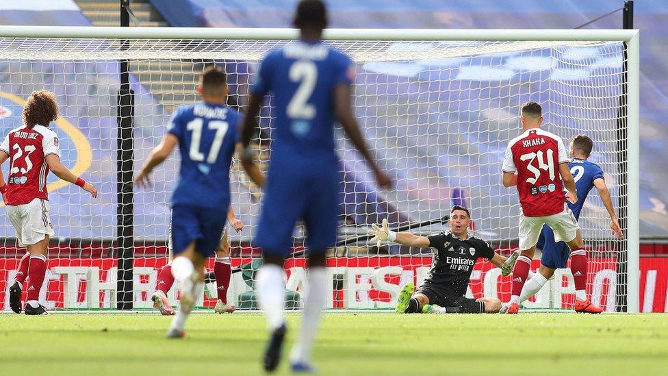 Chelsea's midfielder Christian Pulisic scores the opening goal past Arsenal's Argentinian goalkeeper Emiliano Martinez during the English FA Cup final football match between Arsenal and Chelsea at Wembley Stadium