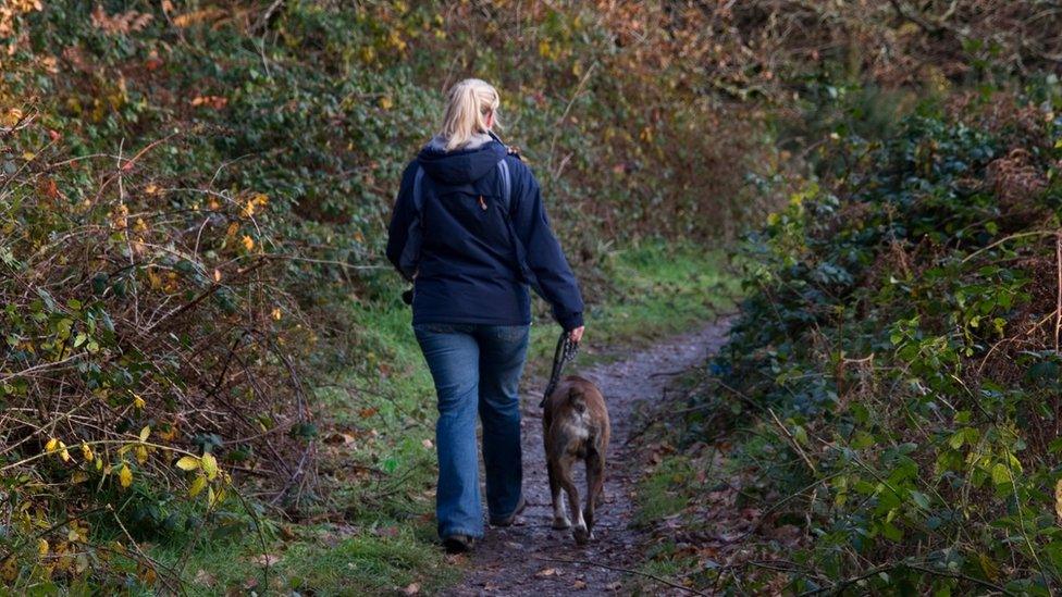 Woman walking a dog on a lead