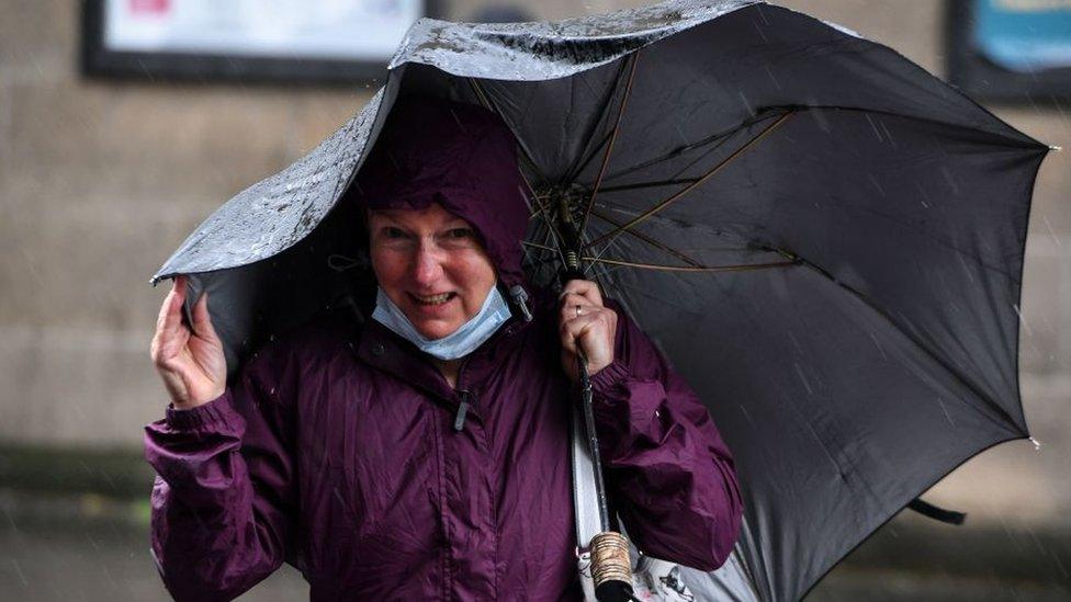 Woman shelters under umbrella