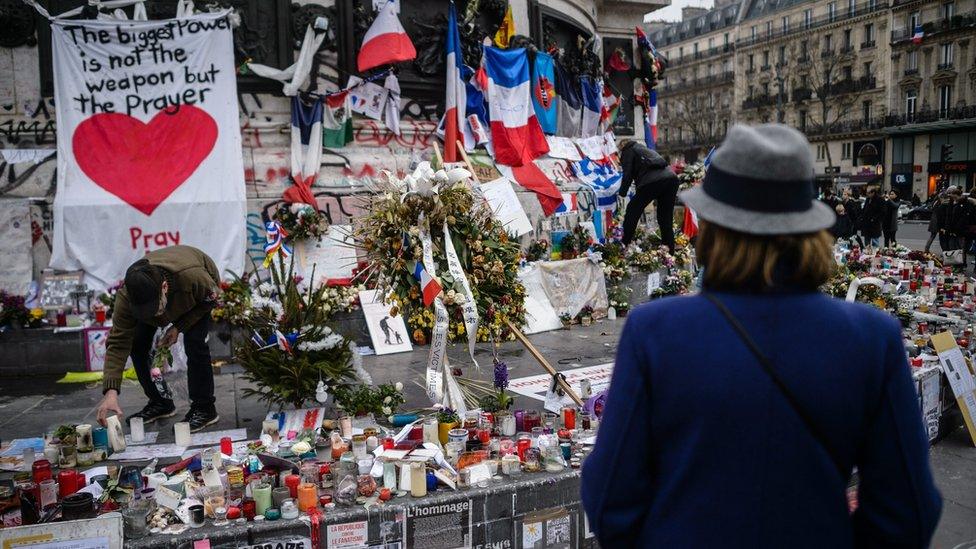 One month after the Paris attacks, people continue to gather in front of the memorial of candles and flowers for the victims of the 13 November Paris attacks, on Place de la Republique in Paris, France, 13 December 2015