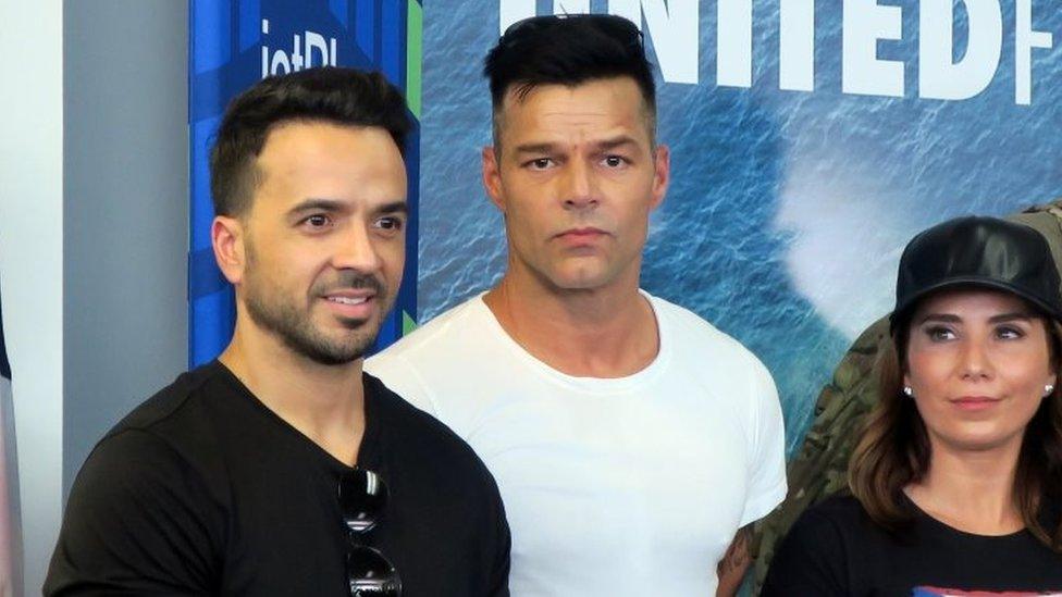 Puerto Rican singers Luis Fonsi (L) and Ricky Martin (C), accompained by well-being and of the health activist , Laura Posada (R), attend a press conference at the Luis Munoz Marin International airport in San Juan, Puerto Rico, 02 October 2017.