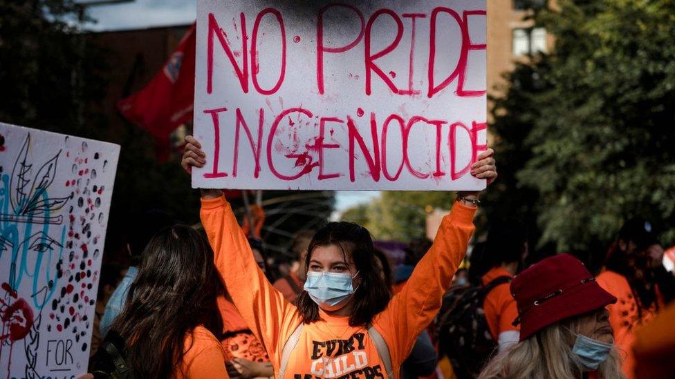 A woman holds a placard during the "Every Child Matters" march to mark the first National Day for Truth and Reconciliation in Montreal, Canada on September 30, 2021