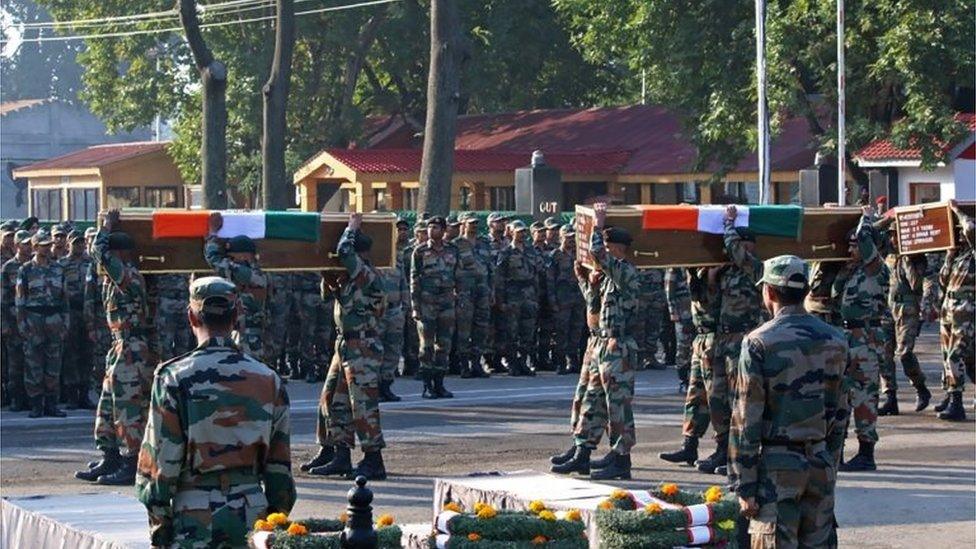 Indian army soldiers carry the coffins of colleagues during a wreath laying ceremony for 17 Indian army soldiers killed in a gunbattle at the army headquarters in Srinagar on September 19, 2016.