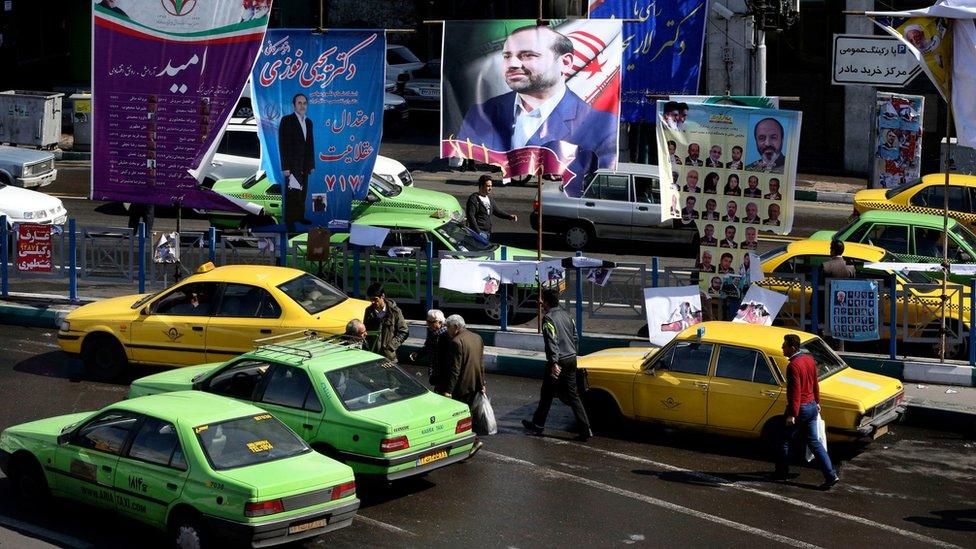 Iranians catch taxis under election banners in Tehran (24 February 2016)