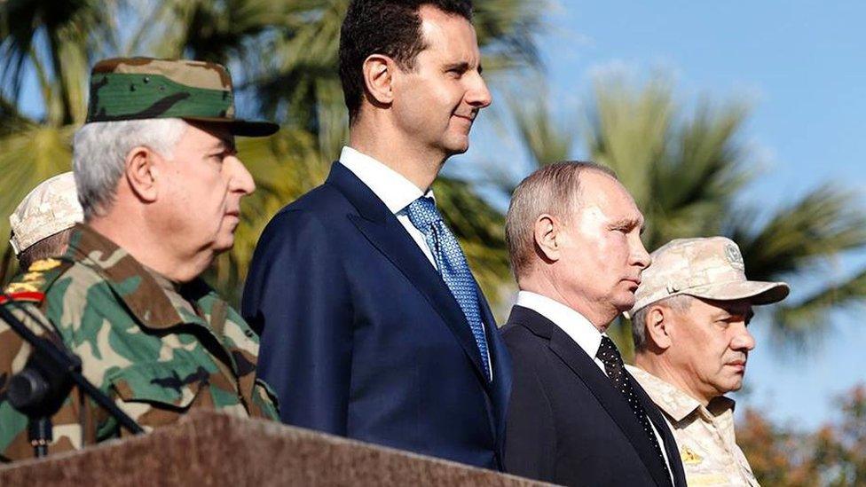 Syrian President Bashar al-Assad (2nd Left) and Russian President Vladimir Putin (2nd Right) stand beside each other at Russia's Hmeimim airbase near Latakia, Syria