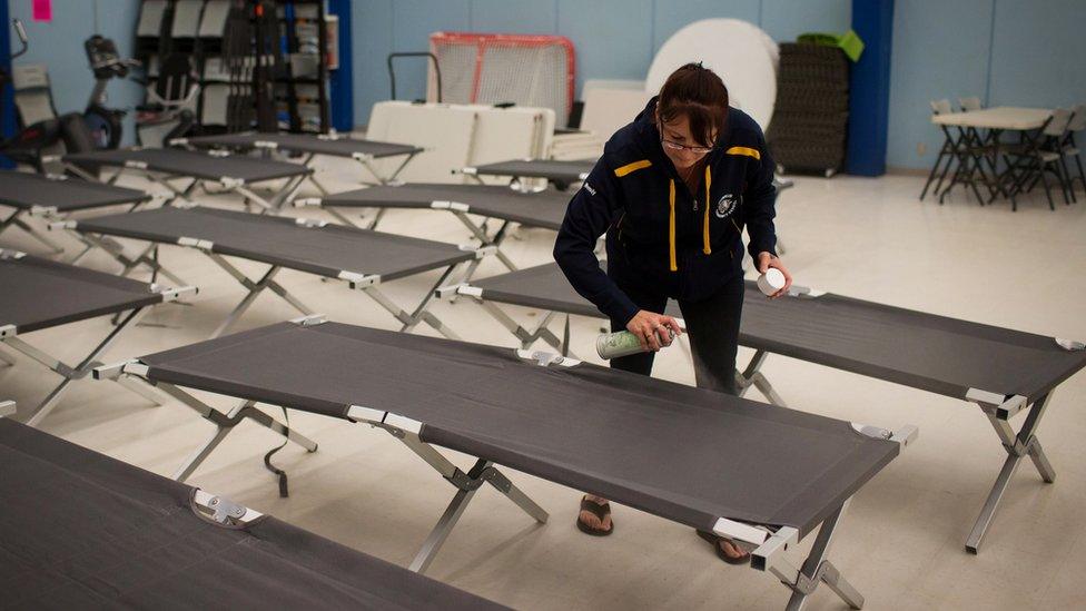 Wendy Tremblay, resident of Conklin, Alta., prepares cots for residents of Fort McMurray