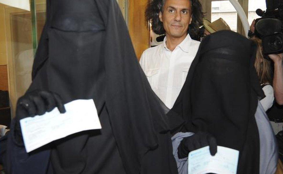 Two women show fines imposed for wearing niqabs in Brussels in 2011. The fines were paid by French businessman Rachid Nekkaz