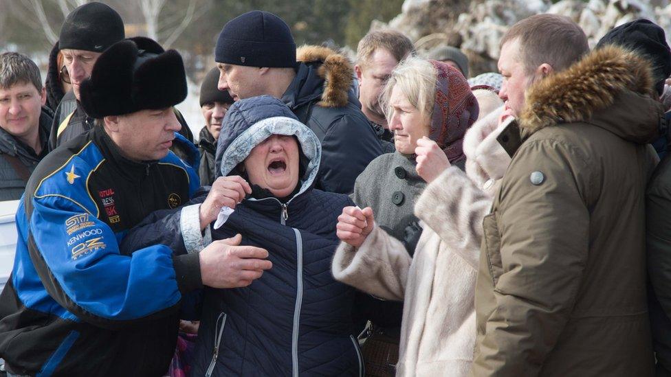 People mourn during a funeral of a victim of a shopping mall fire at a cemetery in Kemerovo, Russia on 28 March 2018