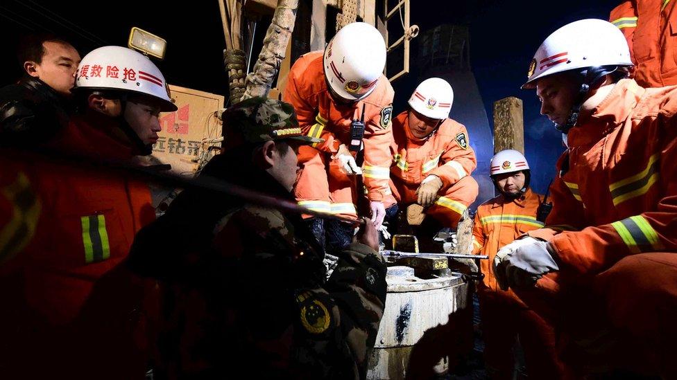 In this Dec. 28, 2015 photo provided by China's Xinhua News Agency, rescuers try to contact the trapped people at a collapsed mine in Pingyi County, east China's Shandong Province.