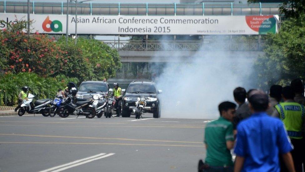 Police hide behind vehicles in Jakarta, Indonesia (14 Jan 2016)