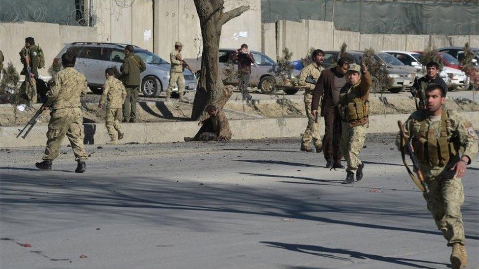 Afghan security personnel gather at the site of a suicide car bomb next to a police base in Kabul on 1 February 2016