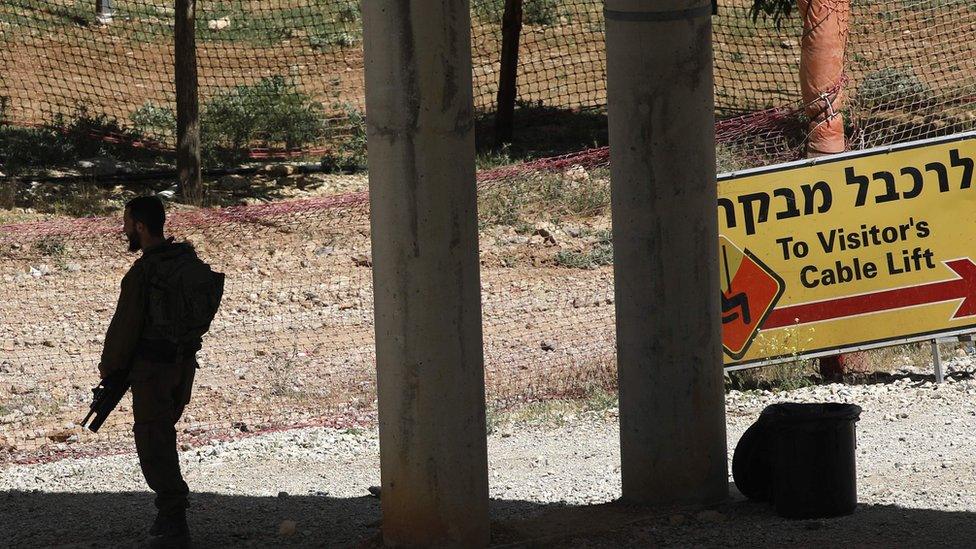 An Israeli soldier based in a military zone in a ski resort stands guard in Mount Hermon, in the Iraeli-annexed Golan Heights from the Syrian side, on June 2, 2019