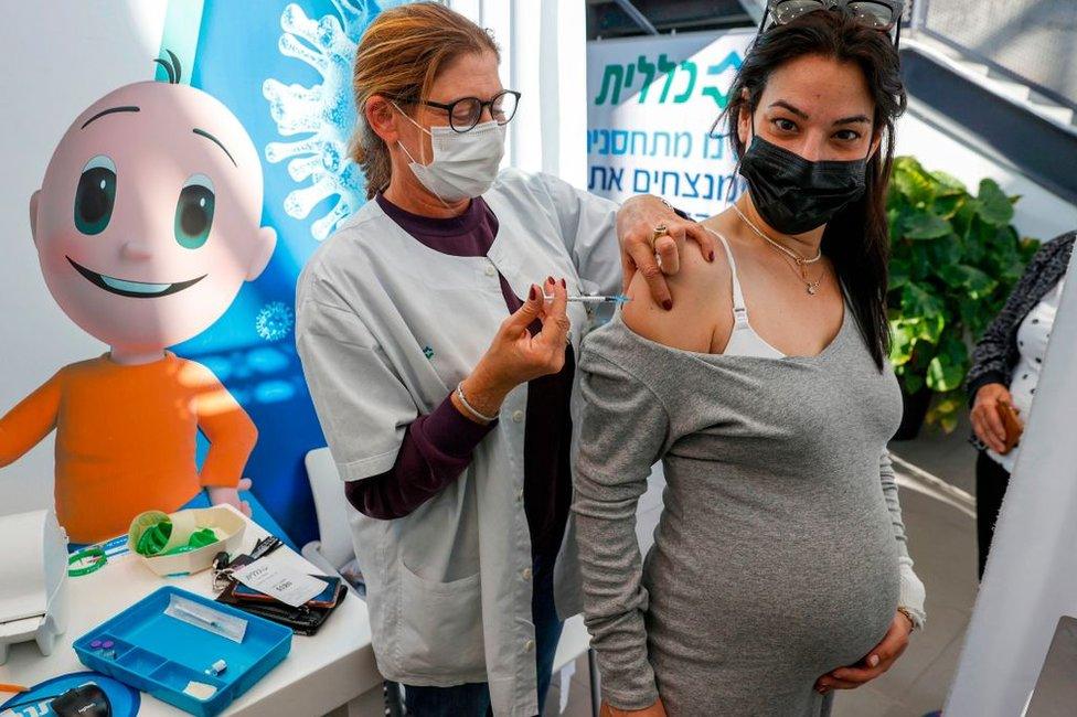 A health worker administers a dose of the Pfizer-BioNtech COVID-19 coronavirus vaccine to a pregnant woman at Clalit Health Services, in Israel's Mediterranean coastal city of Tel Aviv on January 23, 2021.