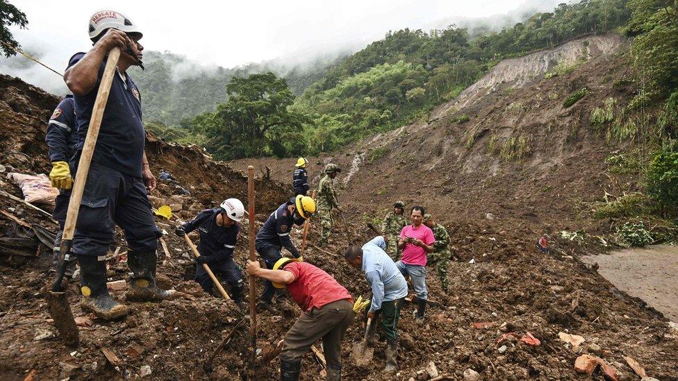 Members of the civil defence and firefighters search for victims