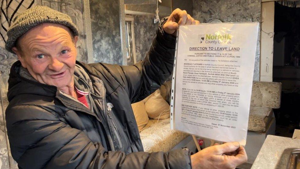 John Smith hold up his eviction paper served by Norfolk County Council.