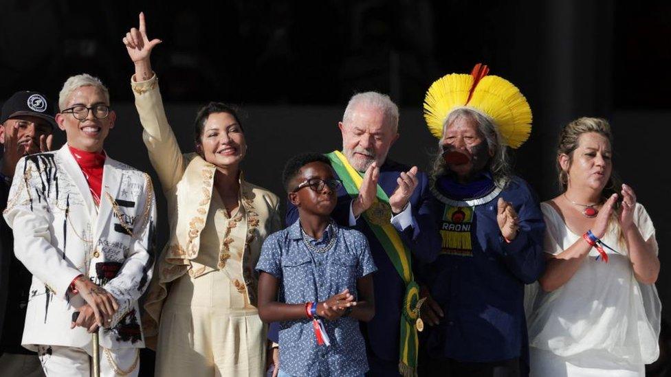 Brazil's President Luiz Inacio Lula da Silva (middle) gclaps his hands after receiving the presidential sash at the Planalto Palace, in Brasilia, Brazil