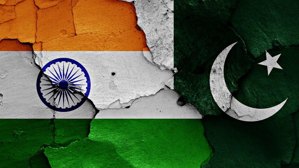 flags of India and Pakistan painted on cracked wall