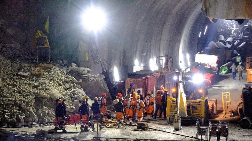 Members of the National Disaster Response Force (NDRF) enter a tunnel where workers have been trapped for ten days after it collapsed