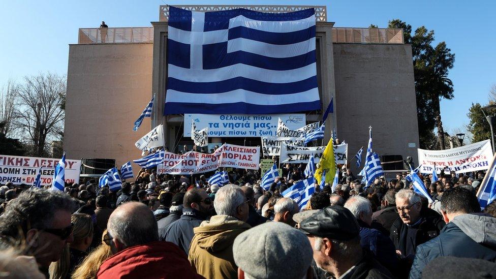 A giant Greek flag hangs on the municipal theatre of the city of Mytilene as locals take part in a protest against overcrowded migrants camps on the island of Lesbos, Greece, January 22, 2020