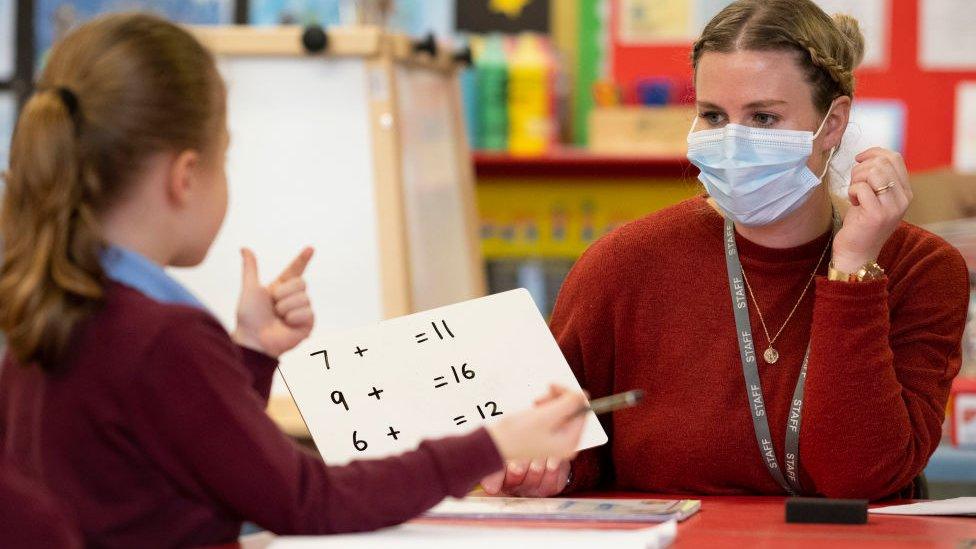 A primary school pupil and teacher in a class room